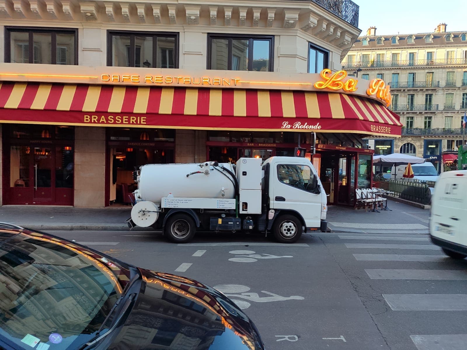 Camion d'assainissement AD Service IDF devant un restaurant parisien
